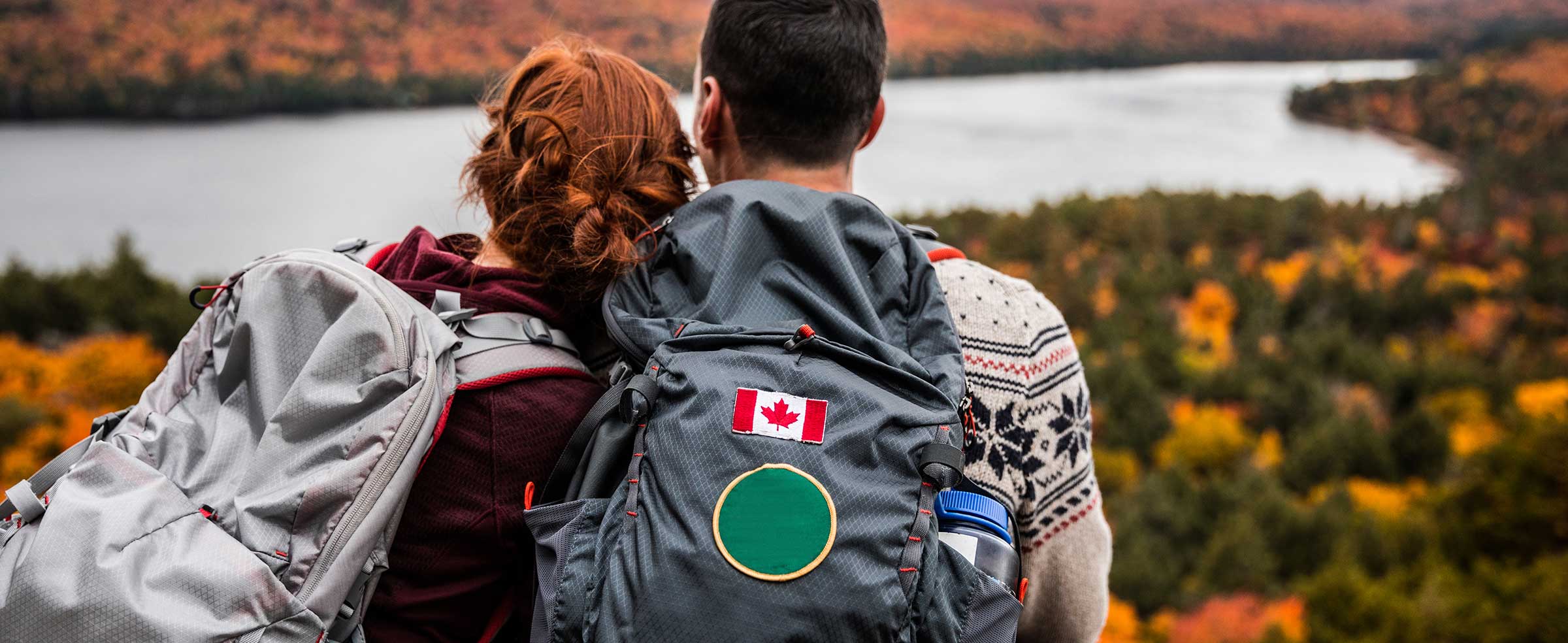 Couple sitting on a mountain overlooking fall foliage